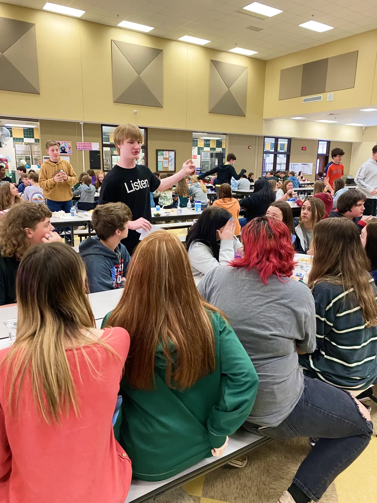 David speaking with students at cafeteria tables