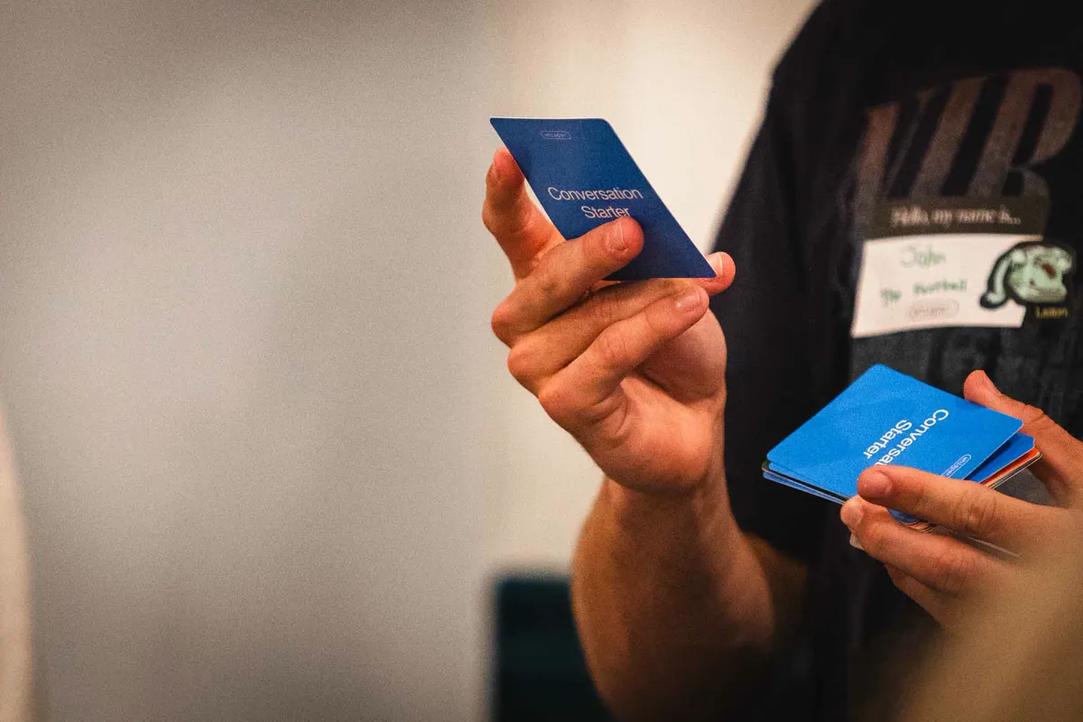 A student holding Whisper conversation cards