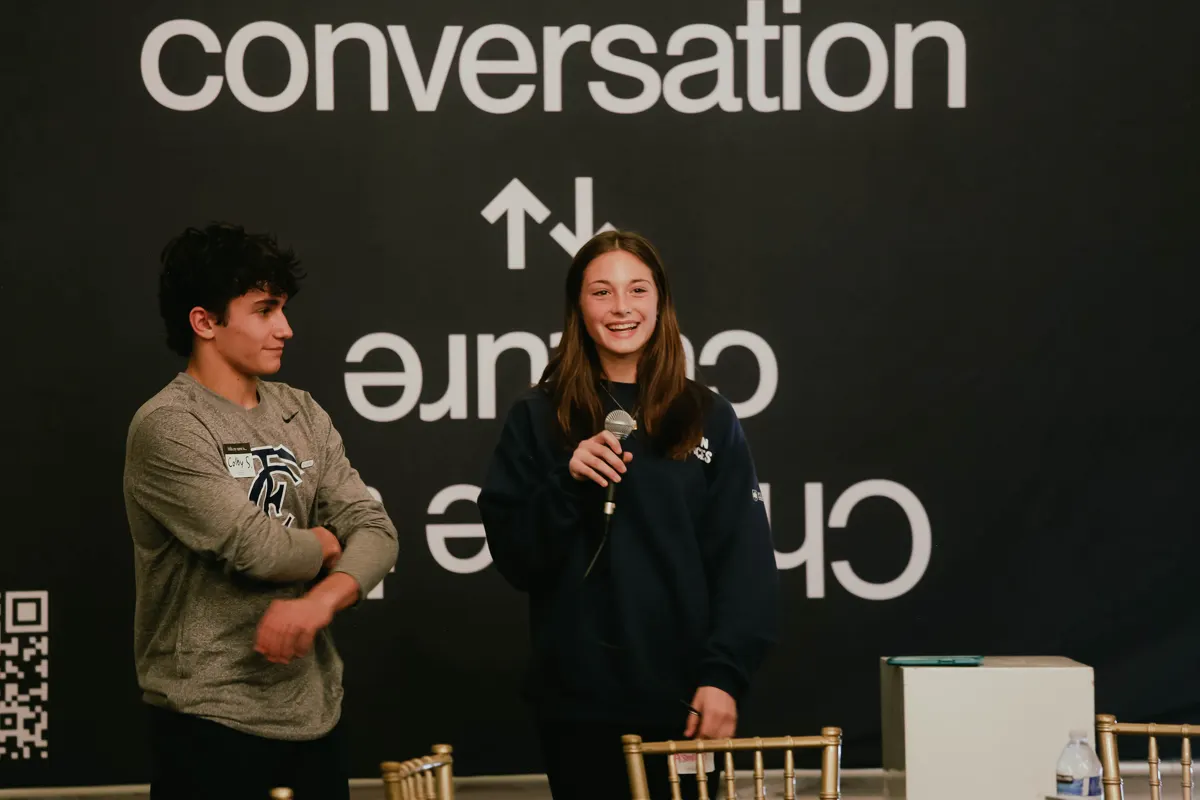 A student leader welcoming everyone into a gathering